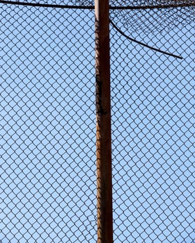 old wire fence made of thin wire against the blue sky photo