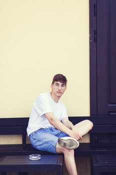 Young man sitting on a bench photo