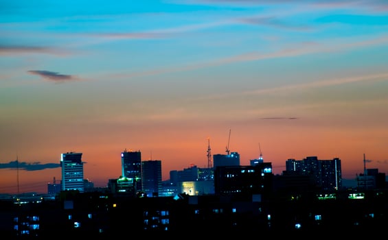 Gives a warm feeling,sunset behind the city building,silhouette city tall buildings,building silhouette again beautiful sky background and freedom concept. photo