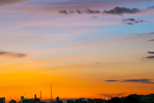 Gives a warm feeling,sunset behind the city building,silhouette city tall buildings,building silhouette again beautiful sky background and freedom concept. photo