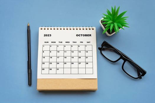 October 2023 desk calendar on blue background. Directly above. Flat lay. photo