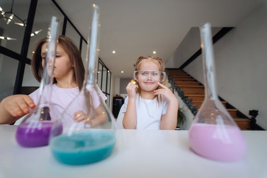Little girls making chemical experiments at home photo
