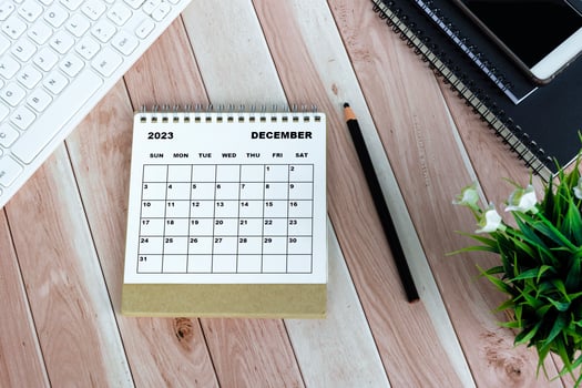 White December 2023 desk calendar on wooden desk. Directly above. Flat lay. photo