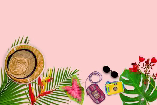 accessories composition for summer concept with tropical palm leaves on pastel pink background, top view and copy space photo