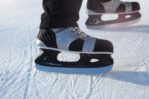 Adult Men's Ice Skates close-up on Ice in Winter outdoor on the move. Rolling and sliding in frosty sunny day, active winter sports and lifestyle photo
