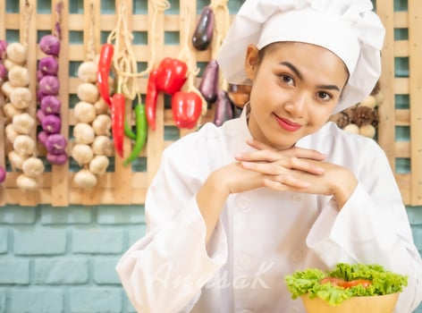 Asian woman in chef's uniform is cooking in the kitchen photo