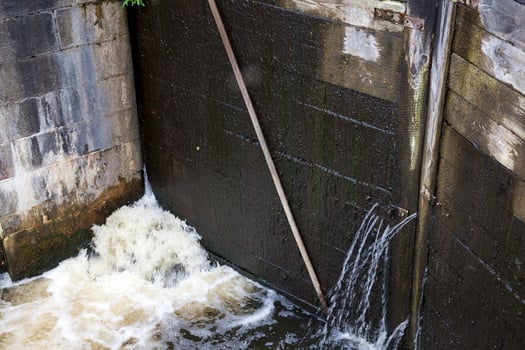 a leaking part of an old wooden dam photo