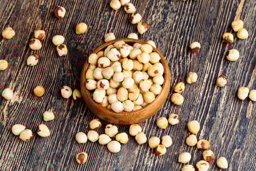 peeled and roasted hazelnuts on a wooden table photo