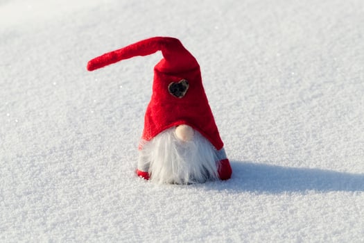 a dwarf with a red hat in the snow photo