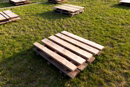 wooden pallets on the grass, close up photo