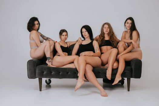 Diverse models wearing comfortable underwear posing on a large sofa photo