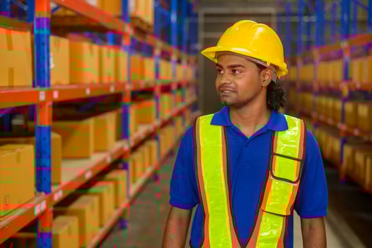 Portrait of young mixed race male worker wearing helmet in modern warehouse storage of retail shop photo