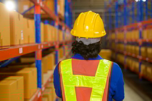Portrait of young mixed race male worker wearing helmet in modern warehouse storage of retail shop photo