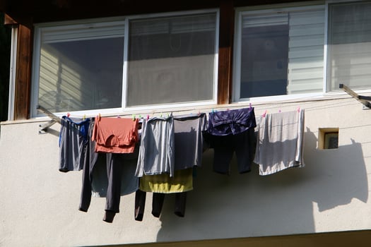 Washed linen dries on the street outside the window of the house. photo