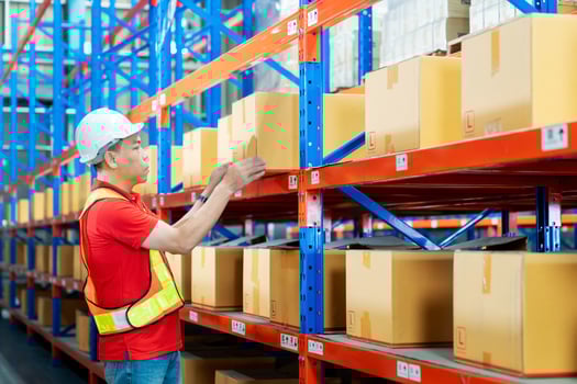 Portrait male foreman inspector in helmets checking box stock at factory storage. Man supervisor counting box inventory. Warehouse worker. photo