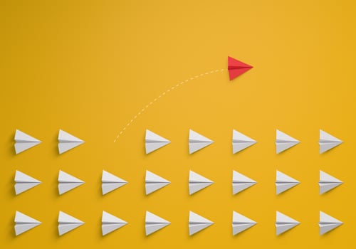 Individual and unique leader red paper airplane changing direction on yellow background. Individuality concept. Think different. photo