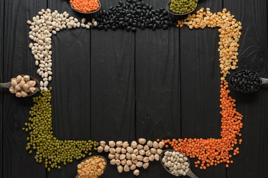Legumes, overhead flat lay shot on a dark rustic wooden background with a place for text photo
