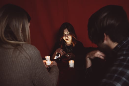 Group of people and woman fortune teller with crystal ball photo