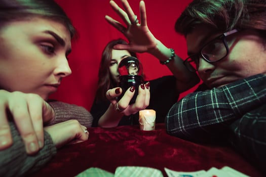 Group of people and woman fortune teller with crystal ball photo