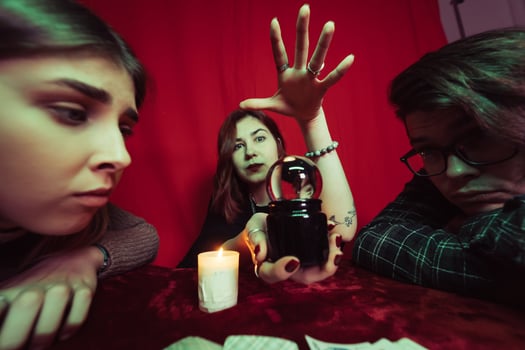 Group of people and woman fortune teller with crystal ball photo