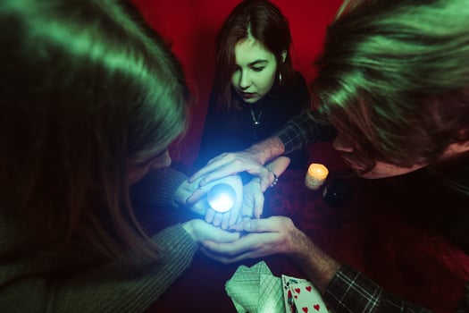 Group of people and woman fortune teller with crystal ball photo