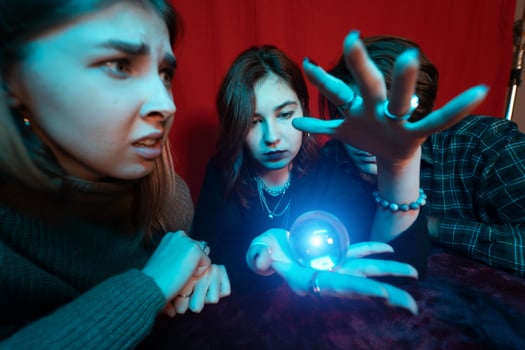 Group of people and woman fortune teller with crystal ball photo