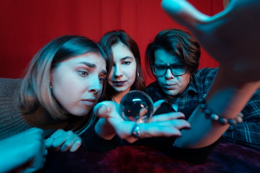 Group of people and woman fortune teller with crystal ball photo