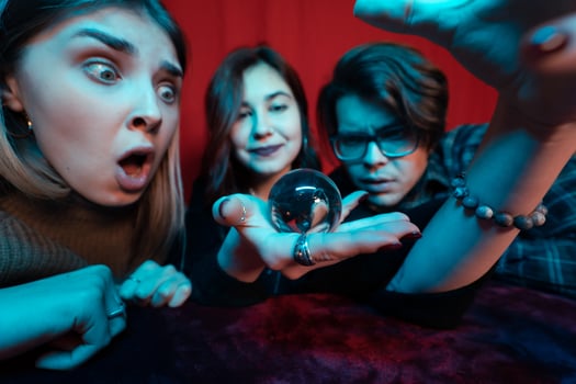 Group of people and woman fortune teller with crystal ball photo