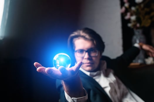 Young man holding a clear transparent crystal glass ball in their hand photo