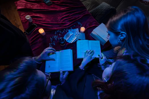 Two women and a guy are reading a mysterious books, close view photo