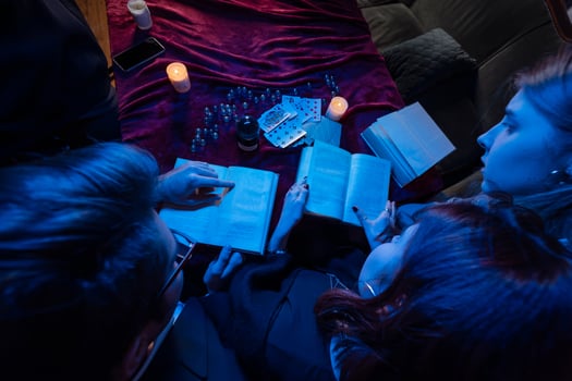 Two women and a guy are reading a mysterious books, close view photo