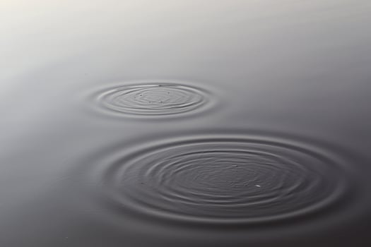 Detailed close up view on water surfaces with ripples and waves and the sunlight reflecting at the surface photo