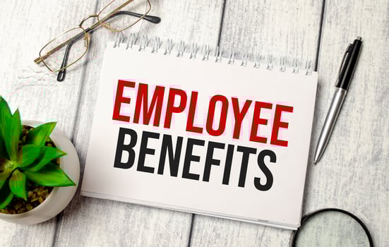 Employee Benefits words on notepad and pen, calculator and glasses photo