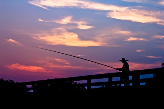 Man fishing in sun set. photo
