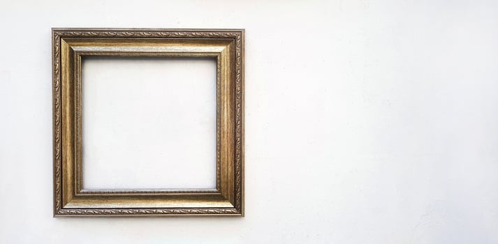 Golden or brown picture frame mockup on white concrete wall with copy space. Framework isolated on background. photo