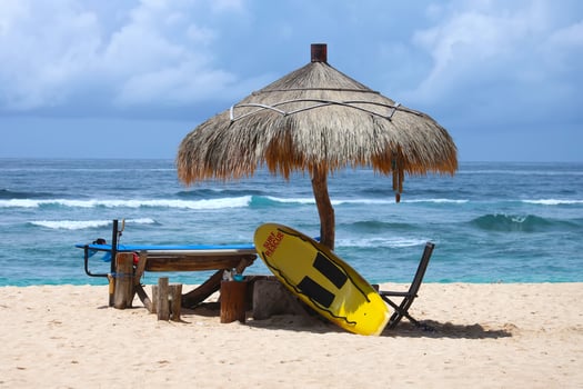 Lifeguard station on the beach with yellow surf rescue board on it photo
