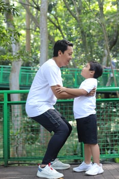 Happy Asian father and son playing and having fun outdoors. Family, childhood and fatherhood concept photo