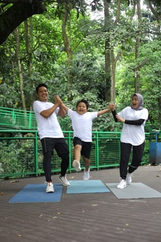 Asian family having fun exercising sport together at the park. photo