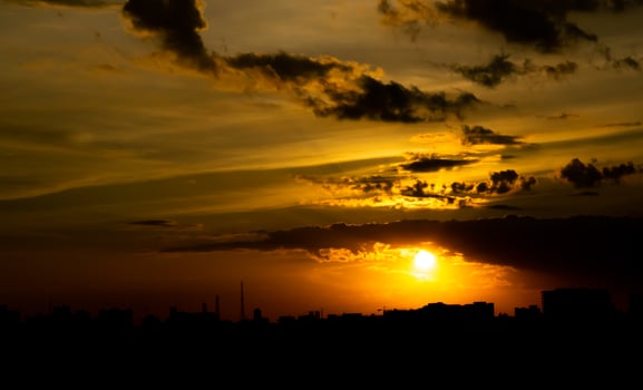 Gives a warm feeling,sunset behind the city building,silhouette city tall buildings,building silhouette again beautiful sky background and freedom concept. photo