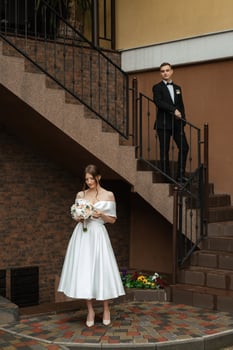 young couple bride and groom in a white short dress photo