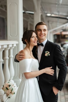 young couple bride and groom in a white short dress photo