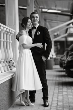 young couple bride and groom in a white short dress photo