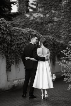 young couple bride and groom in a white short dress photo