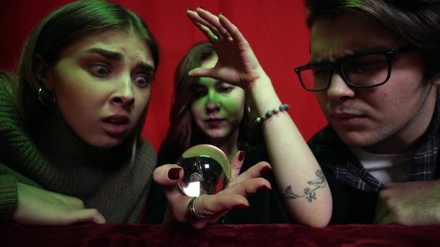 Group of people and woman fortune teller with crystal ball photo