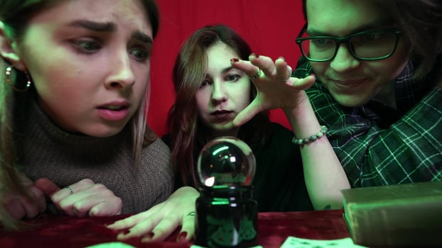 Group of people and woman fortune teller with crystal ball photo