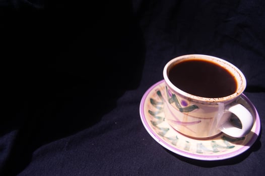 a glass containing brewed black coffee on a black background photo