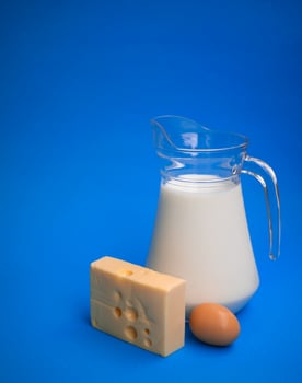 Dairy products. Milk, egg and cheese on a blue background photo