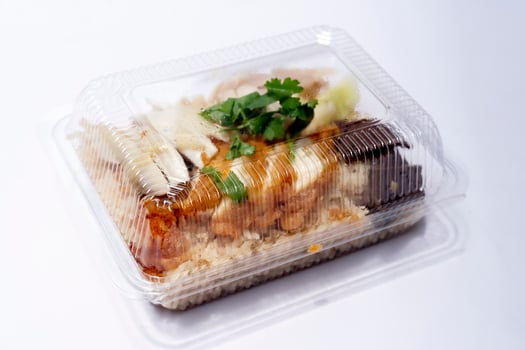 Side view of plastic box for food of Hainanese chicken glutinous rice mix with Fried Chicken. On white floor or isolated white background. photo