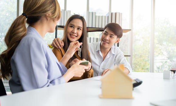 The real estate agent gives the key to client after signs the home loan document with the real estate property agent or lawyer.  Concept of insurance or loan real estate, buy a house. photo