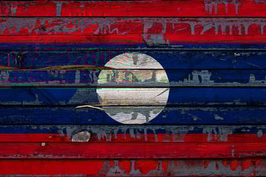 The national flag of Laos is painted on uneven boards. Country symbol. photo